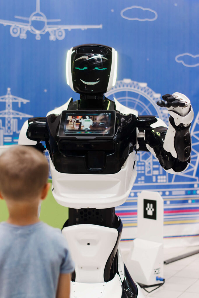 a boy looks at a robot at a robot exhibition artif